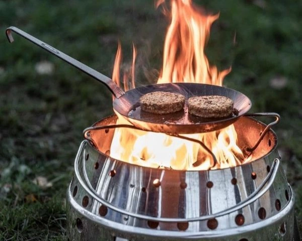 Tigaie din fier forjat cu bucati de carne pe flacara gratarului Petromax