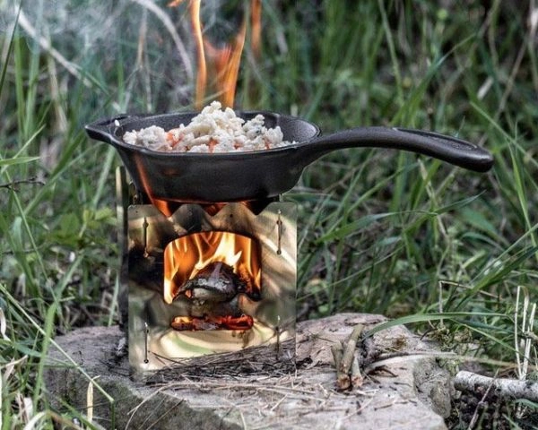 Tigaie de fonta cu mancare direct pe flacara, la iarba verde